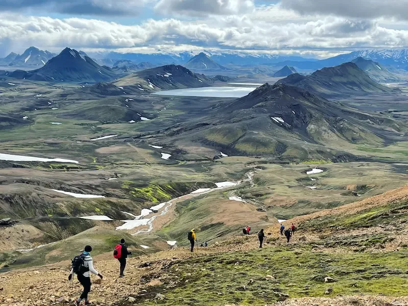hikers on laugavegur trek in iceland with mountains in background