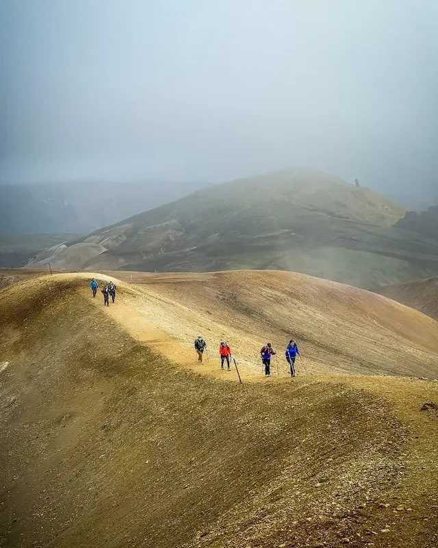 hikers walking on brown hill ridge on laugavegur trek