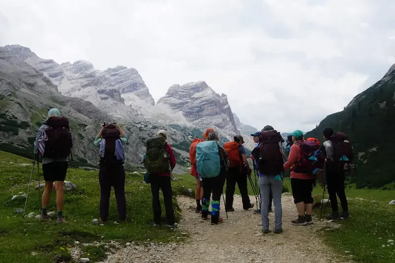group of hikers starting trek in dolomites with low lying clouds