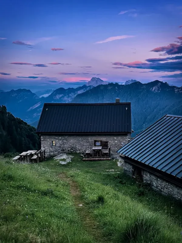 blue and purple sunset in the dolomites with rifugio on edge of mountain