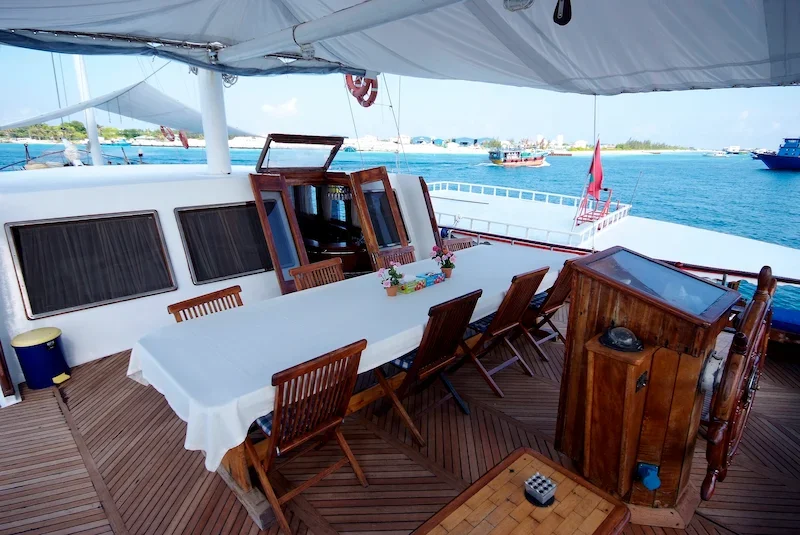 casual deck dining area on sailboat with ocean in distance