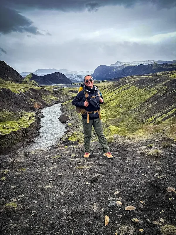 smiling hiker standing in front of river on laugavegur trek