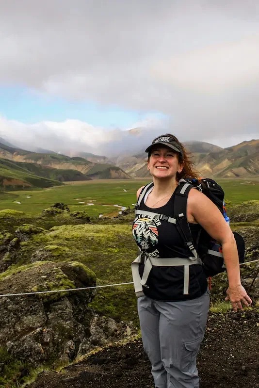 woman hiker smiling in front of iceland green field