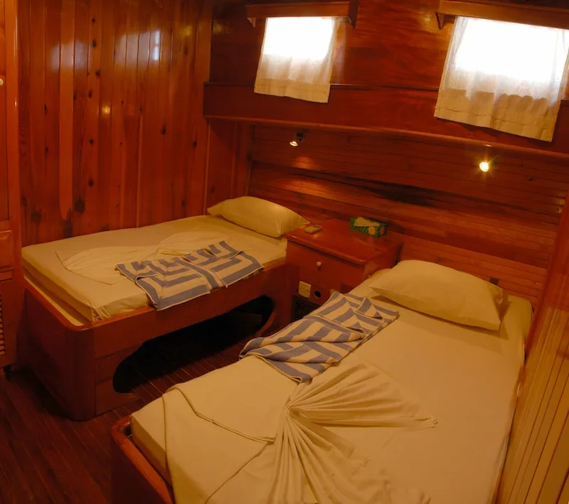 two twin beds in a wooden room on sailboat
