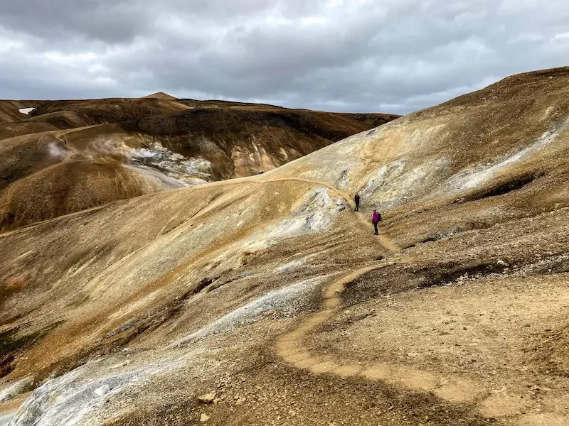 hikers in volcanic area and brown hills on laugavegur trek in iceland