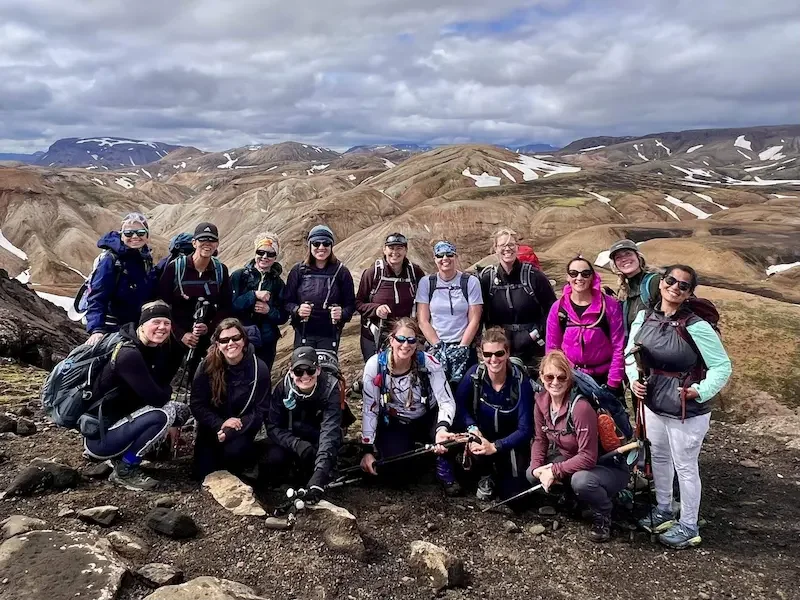 group of women hikers with brown and snowing hills in background in iceland