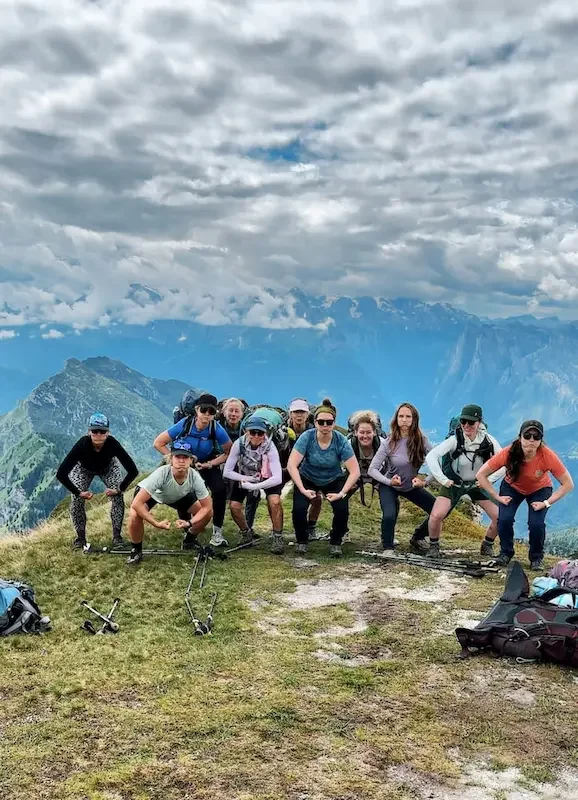 women in strong muscle pose in mountains