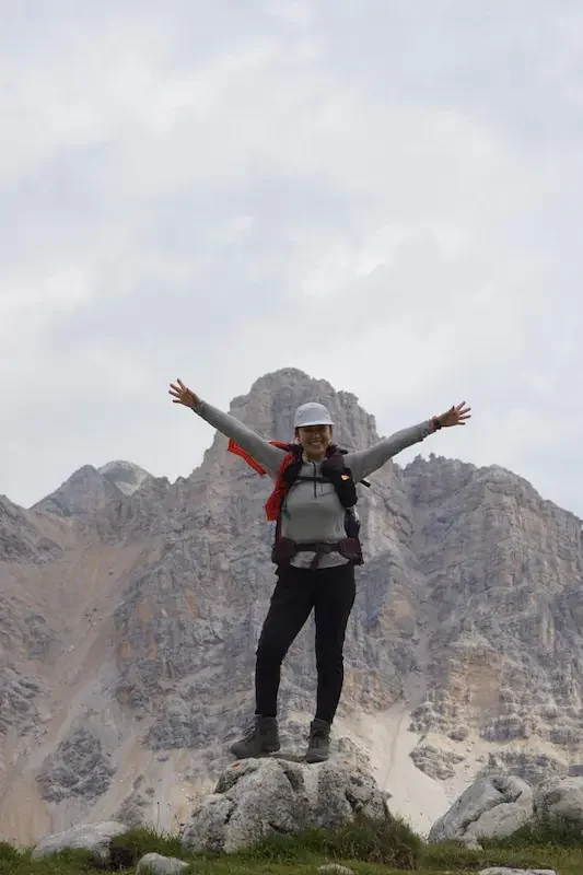 woman hiker standing on rock in front of big mountain