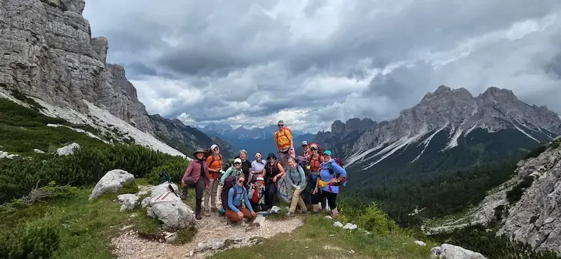 group of women hikers standing in front of mountainous dolomite landscape