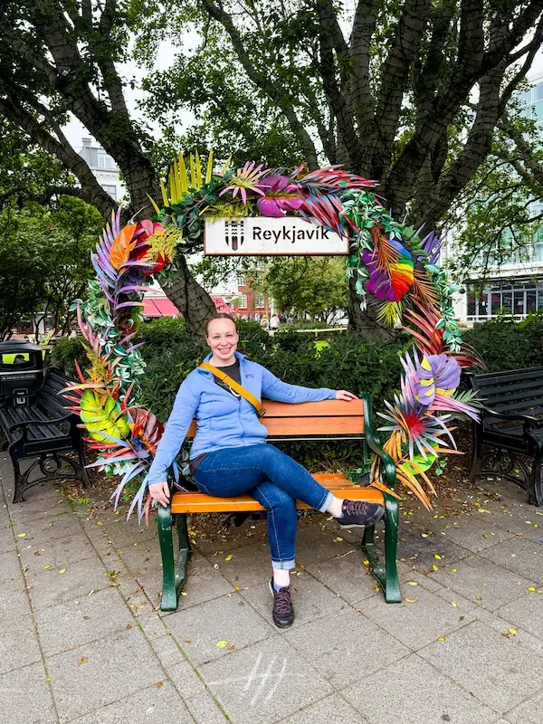 woman sitting on bench in reykjavik surrounded by flower arch
