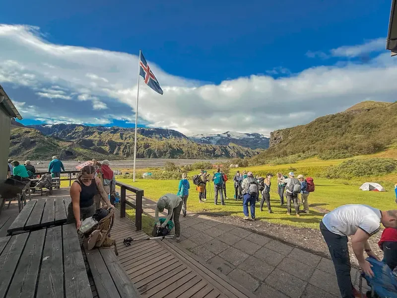 many people standing around on patio or grassy area at hut on the laugavegur trek
