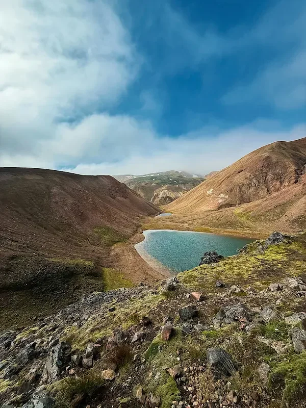 small lake surrounded by brown hills in iceland