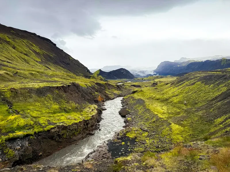 small valley with river and green hills in iceland