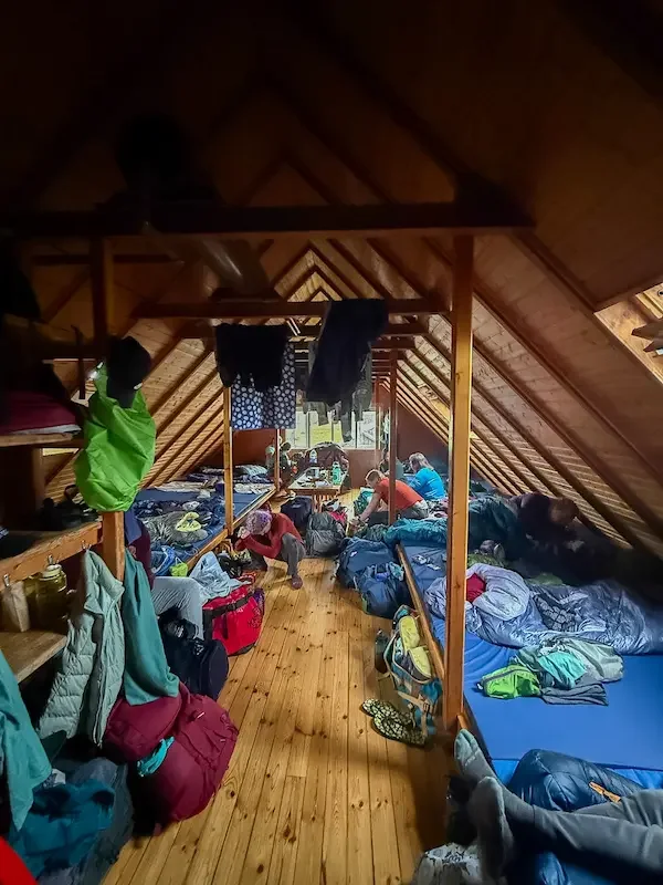 inside sleeping area of hut on laugavegur trek that has hikers gear hanging up