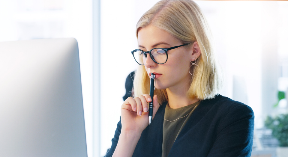 Professional woman thoughtfully reviewing financial decisions about paying off a mortgage or investing.