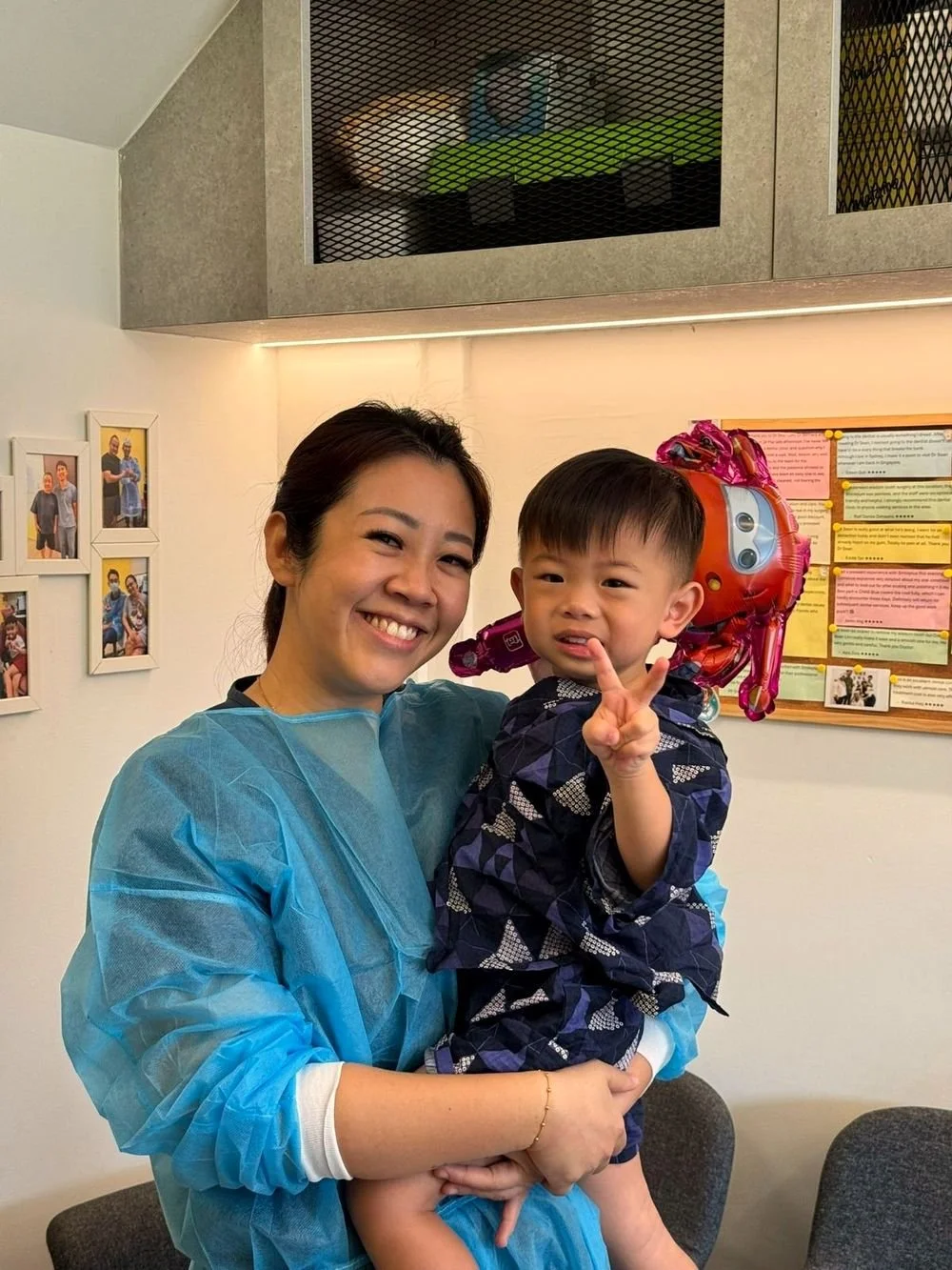 dentist holding a smiling toddler in the clinic