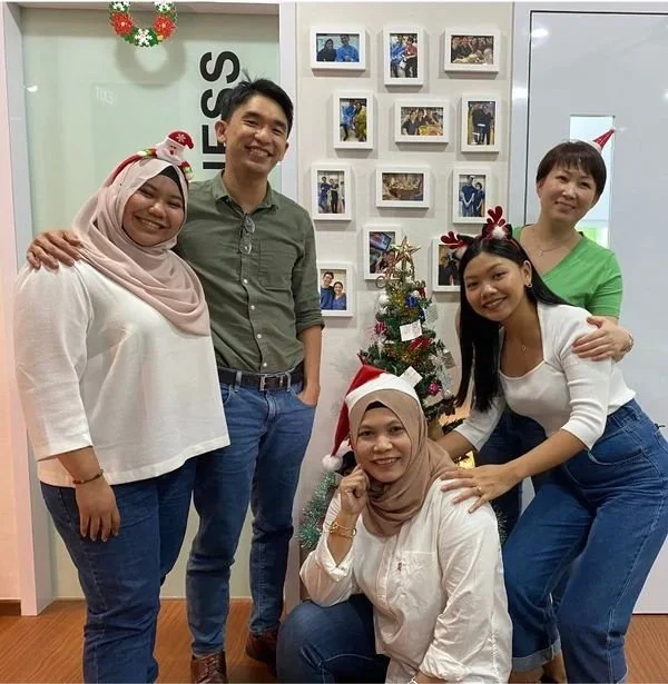 Dentist smiling with four happy staff celebrating christmas together