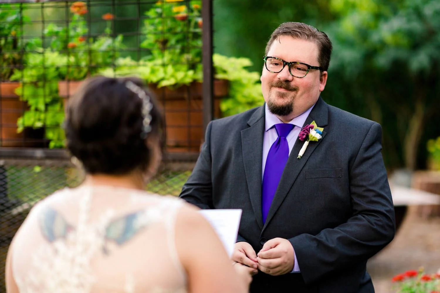 Groom smiling as he reads vows during a simple backyard elopement in Clackamas, Oregon.
