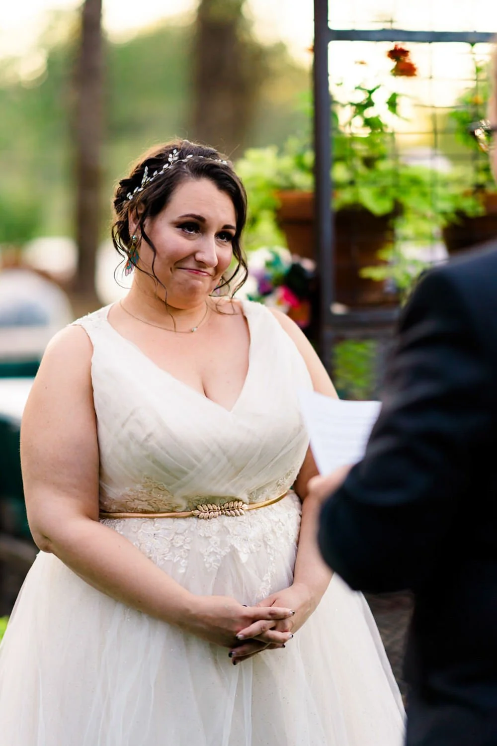 Bride listening emotionally as vows are read during a simple backyard elopement in Clackamas, Oregon.
