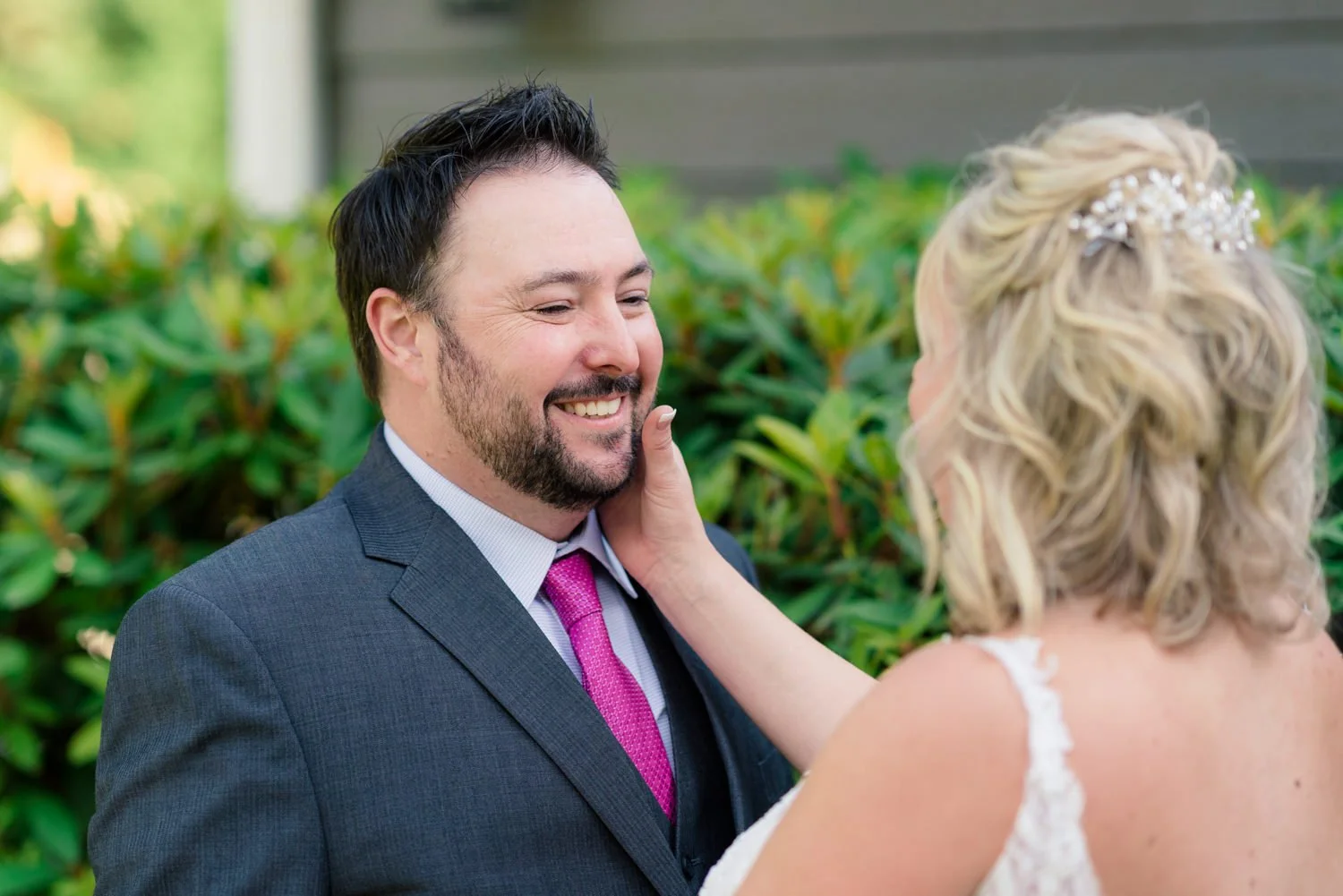 Bride gently touching groom’s face during candid portrait at simple backyard wedding in Vancouver WA.