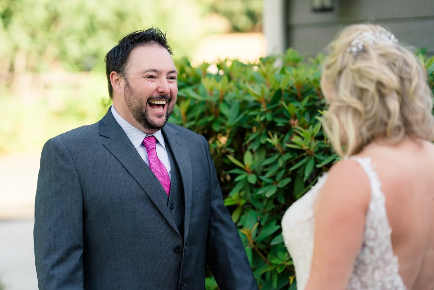Bride and groom smiling at each other during relaxed outdoor portrait session at elegant backyard wedding in Vancouver Washington.