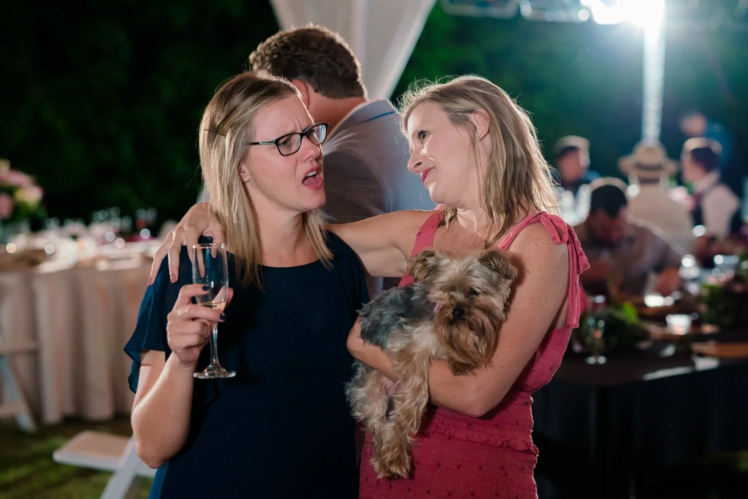 Wedding guests dancing and celebrating on the dance floor at a Vancouver Washington backyard wedding reception, candid night photo with string lights overhead.