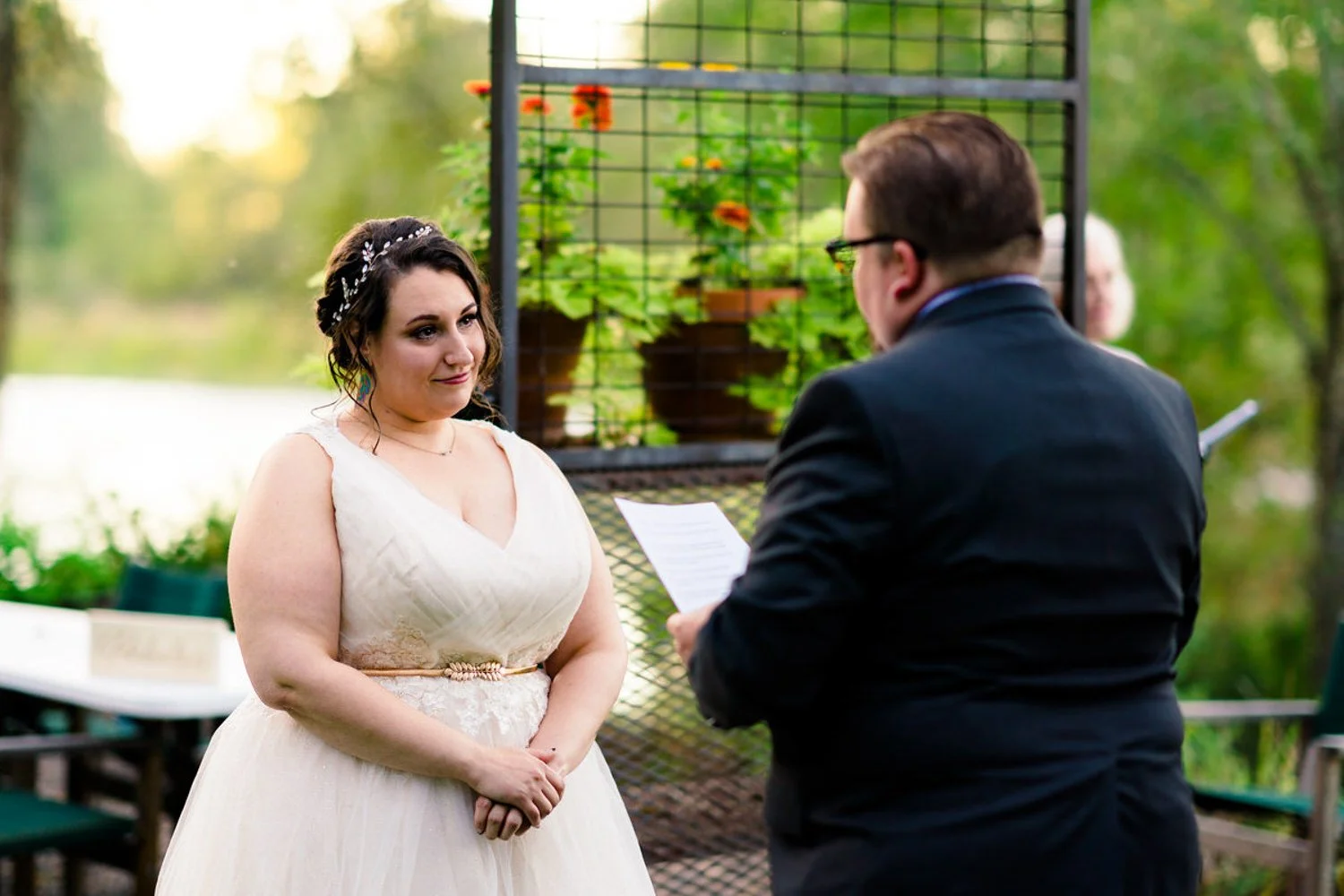 Bride listening as her partner reads vows during a simple backyard elopement in Clackamas, Oregon.