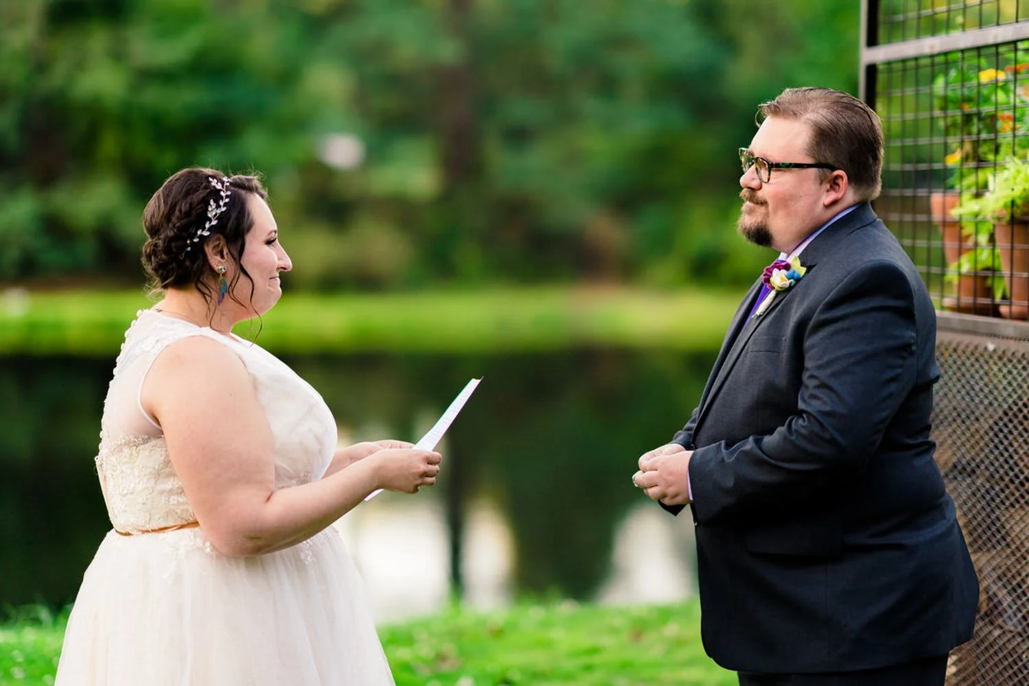 Bride reading vows to her partner during a simple backyard elopement in Clackamas, Oregon by the river.