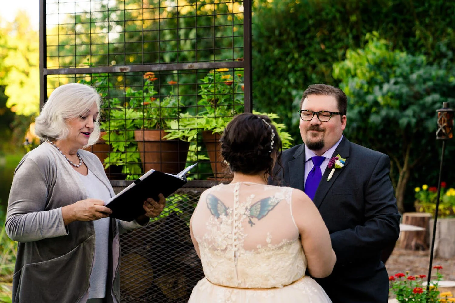 Backyard elopement in Clackamas, Oregon with an officiant and couple during an intimate riverfront ceremony.