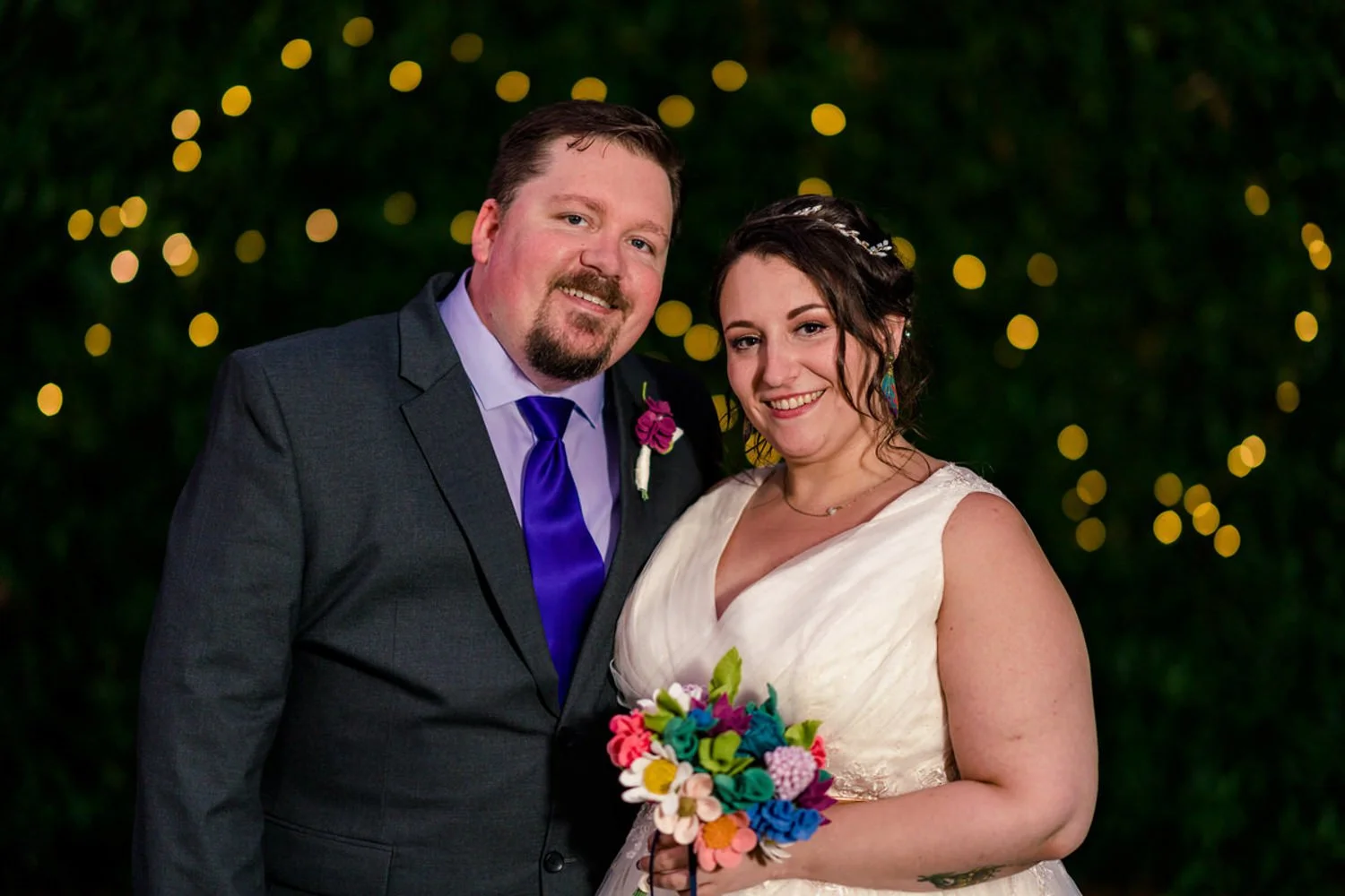 Evening portrait of a newly married couple after an intimate Clackamas elopement, smiling and holding a bouquet.