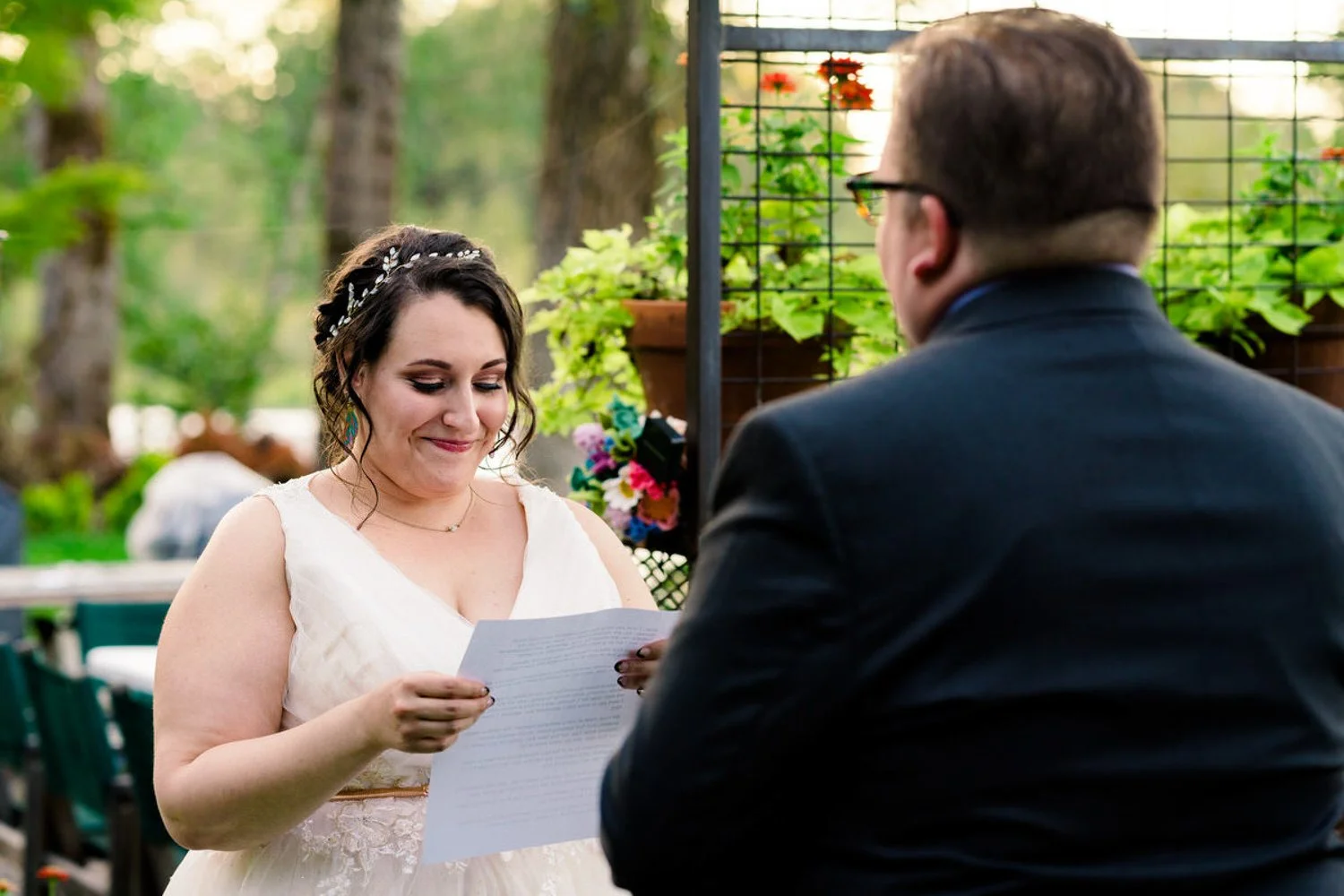 Bride reading her vows during a simple backyard elopement in Clackamas, Oregon surrounded by greenery.