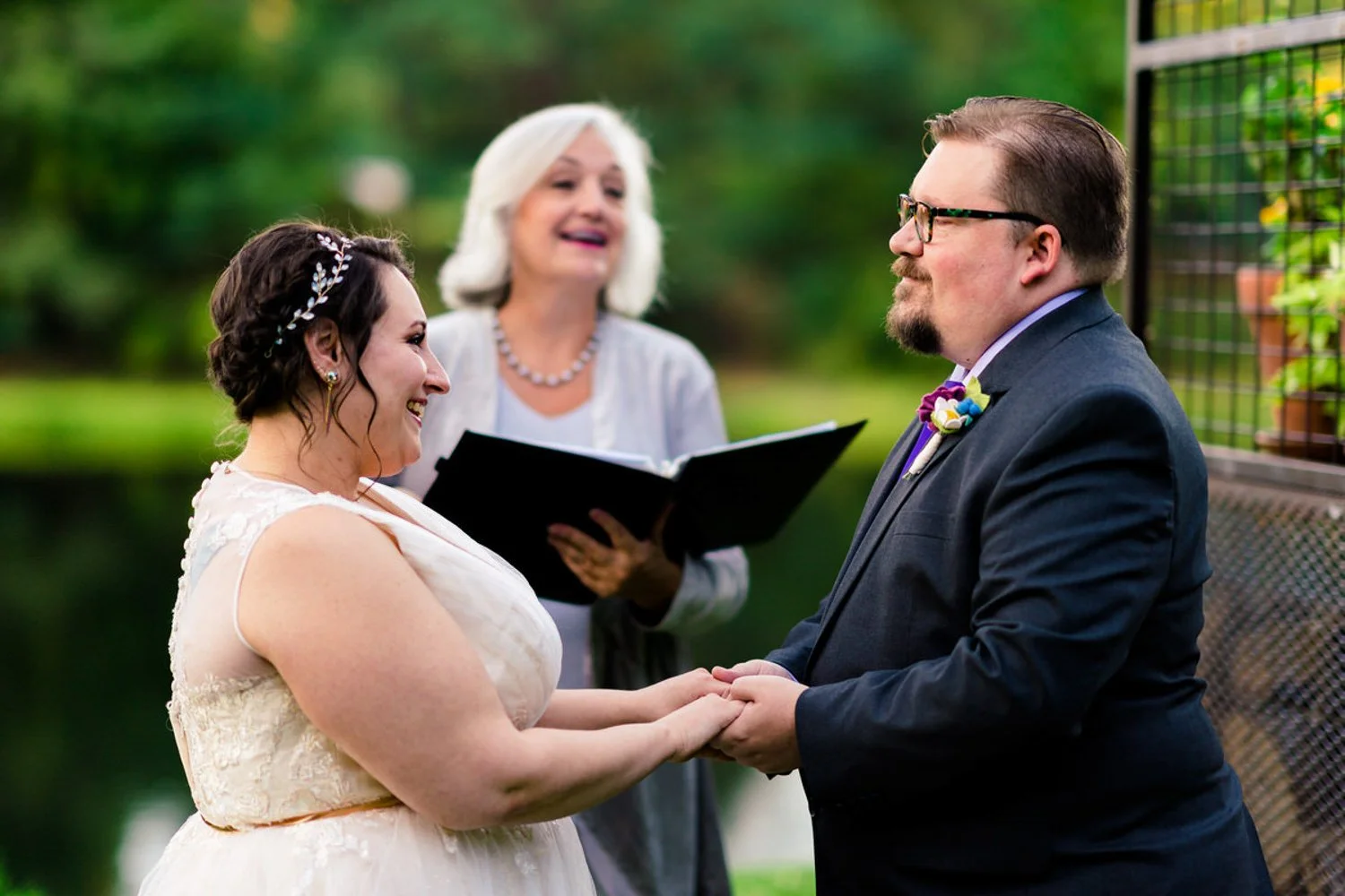 Couple holding hands during a simple backyard elopement in Clackamas, Oregon, officiated beside the Clackamas River.
