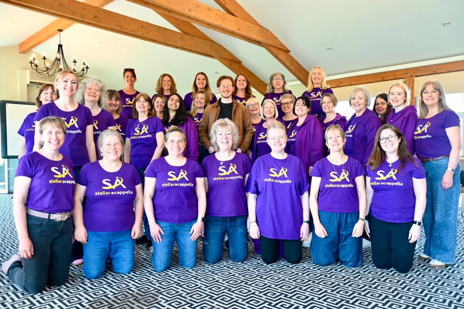A group shot of Owen with the singers of Stellar Acappella, an upper voices ensemble from Essex.