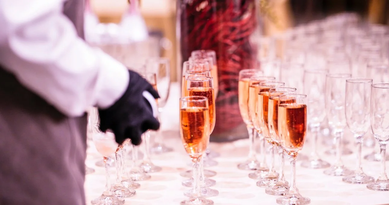 Man wearing glasses in a suit holding a plaque, standing in front of a backdrop with logos and a large star, at an award ceremony.