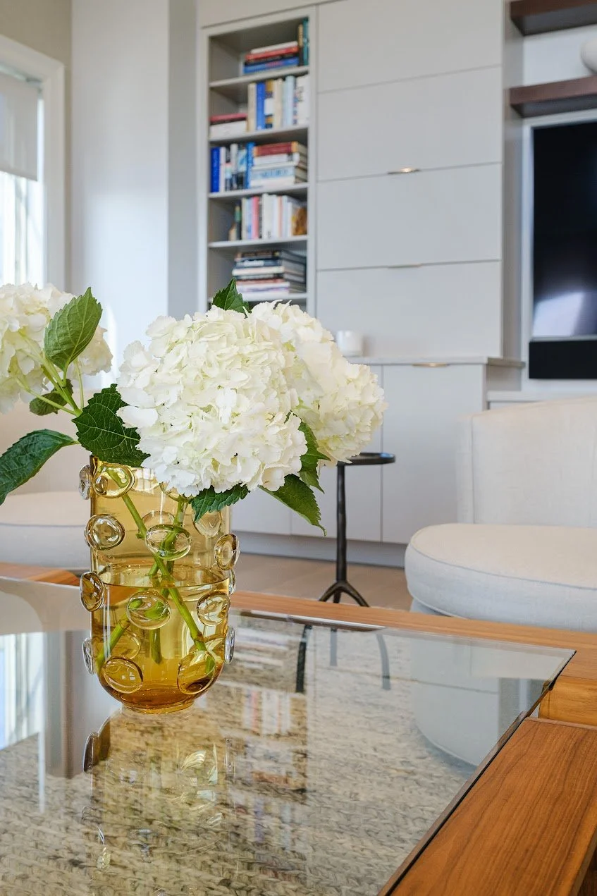 Custom cabinet design by Spice Hill Interiors houses a home office in the open concept living area
