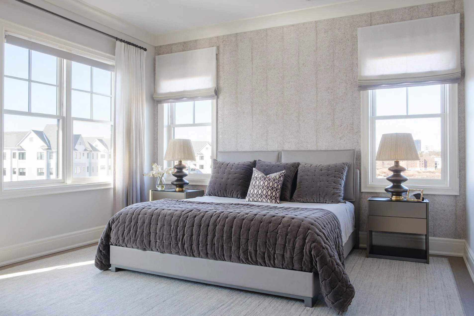Layered textures, ombre drapery, and wallcovering elevates this primary bedroom from new construction to soothing retreat