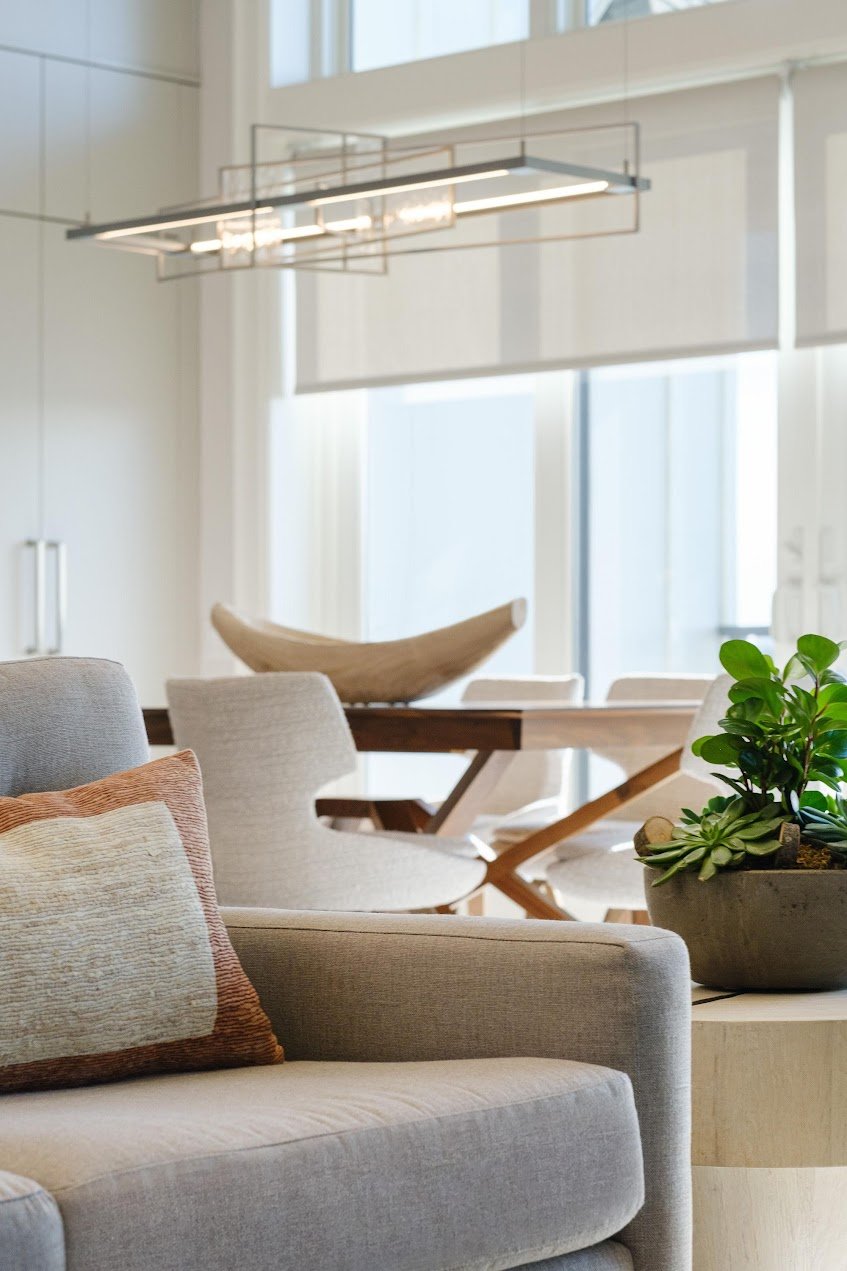 Open-concept interior in a New Rochelle residence featuring neutral furnishings, modern lighting, and layered natural textures.