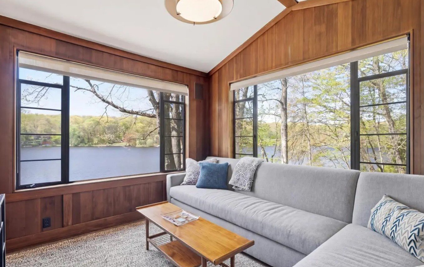 Living room in a Putnam Valley lake house featuring a custom sectional sleeper sofa, layered textures, and natural light.