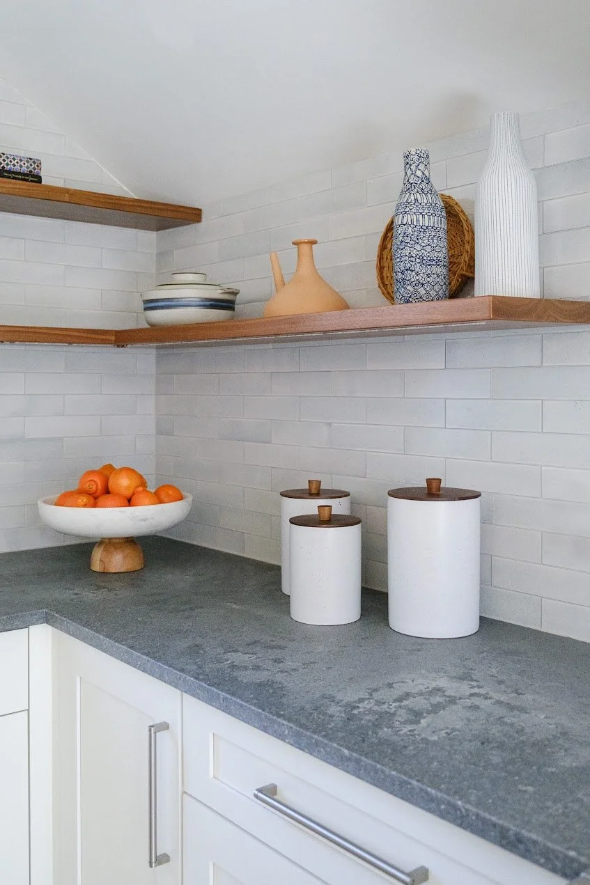 Open corner shelving in a Bronxville Tudor kitchen renovation showcasing custom millwork and decorative storage.
