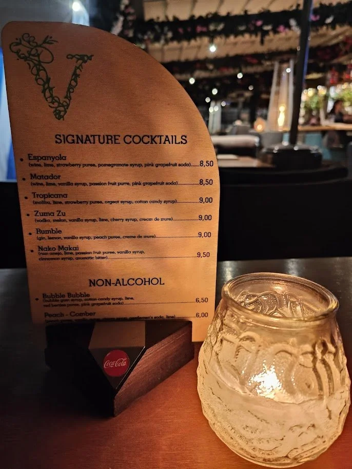 A wooden sign with the signature cocktails