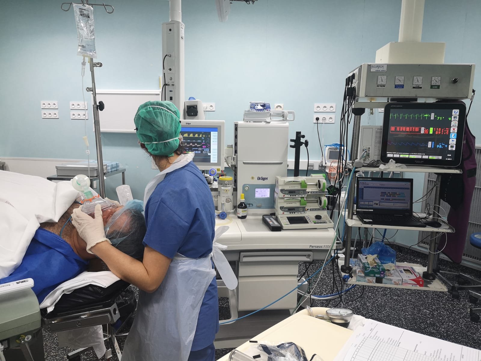 Anesthesiologist in an operating room with a patient under anesthesia.