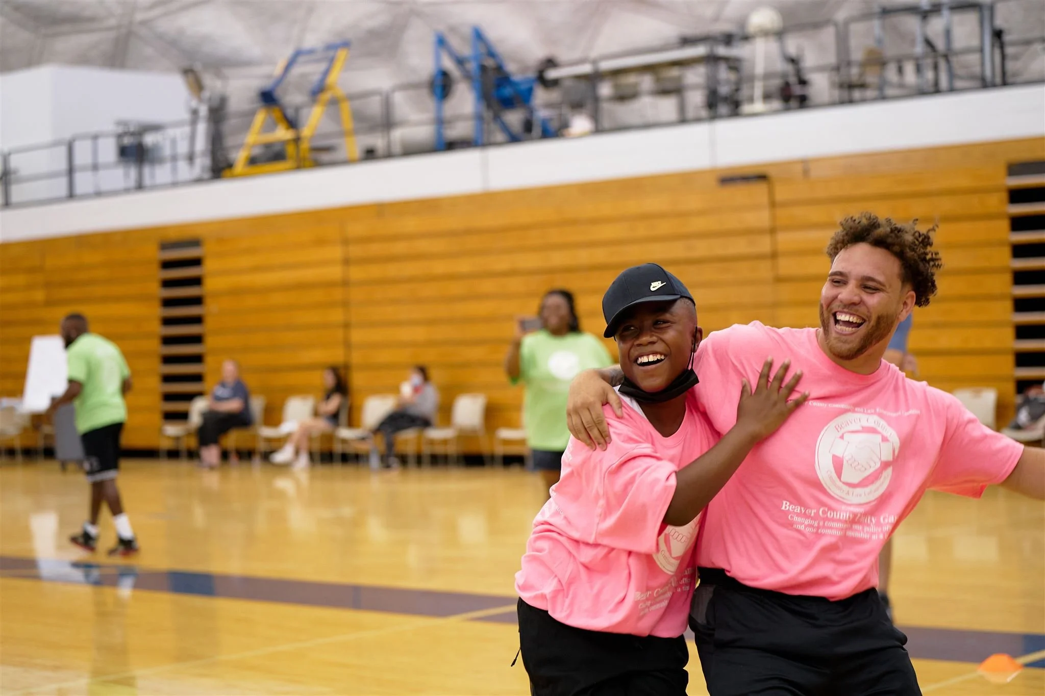 A teenage boy and an adult laugh and smile after having completed an obstacle race during the Beaver County Unity Games at the Community College of Beaver County in Monaca, PA.