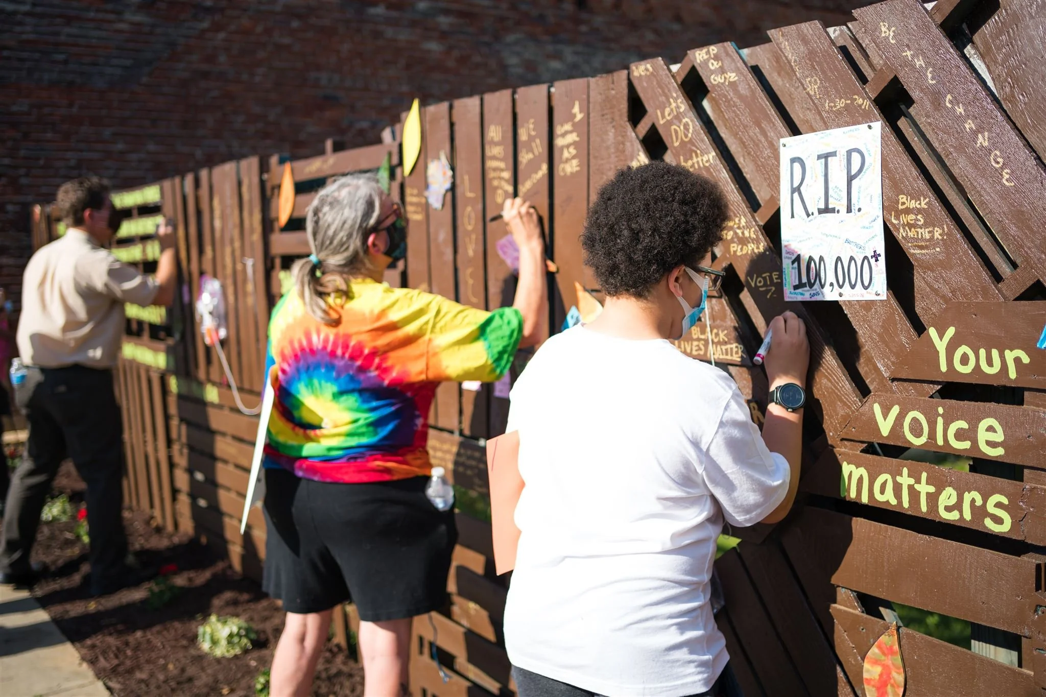 Neighbors in Beaver Falls, PA take a moment to write messages of condolences and hope on a public art display along 7th Avenue mourning lives lost during the COVID-19 pandemic.
