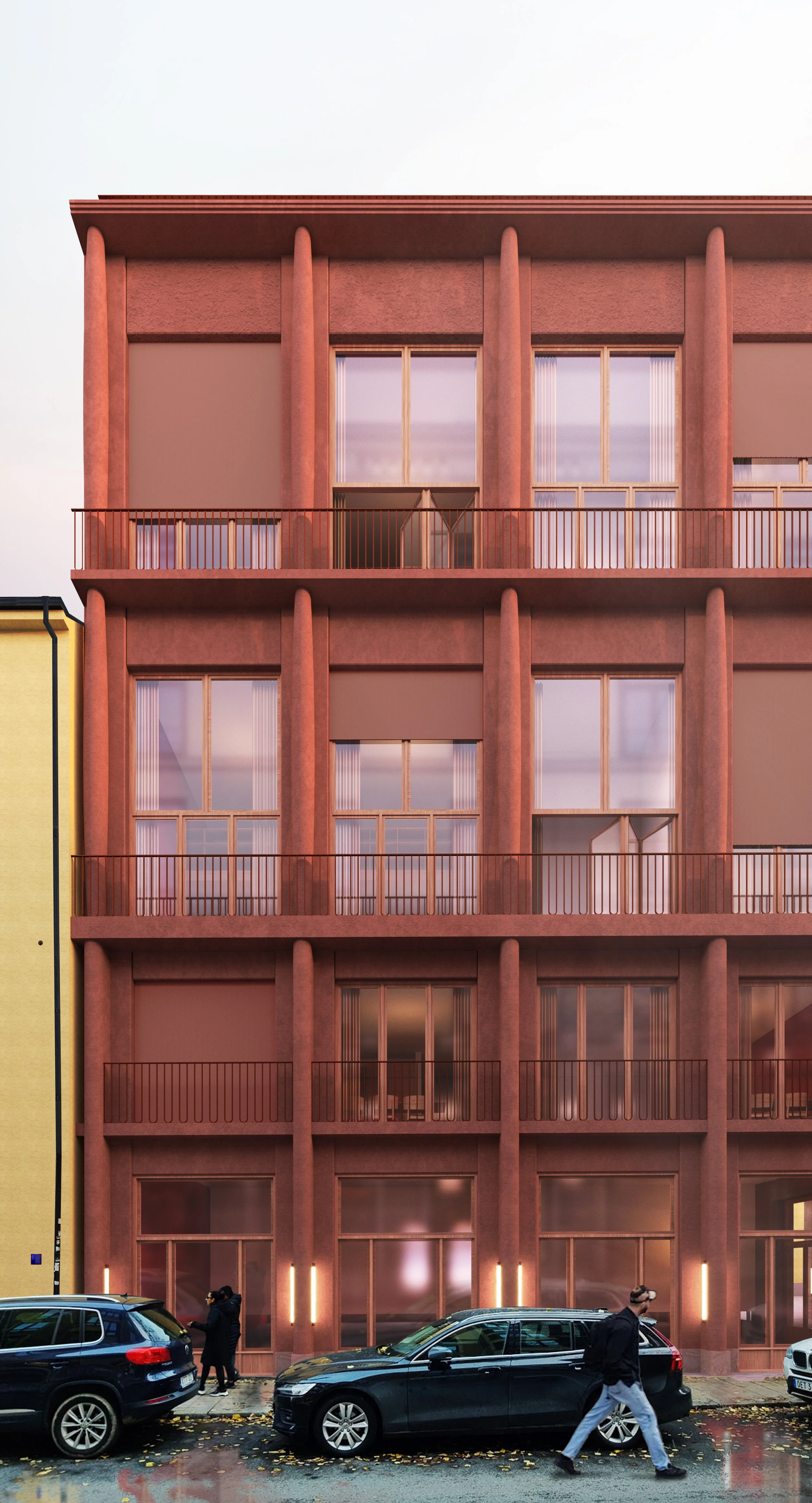 A multi-story pink building with large windows and balconies on each floor, with pedestrians walking on the sidewalk and cars parked in front.
