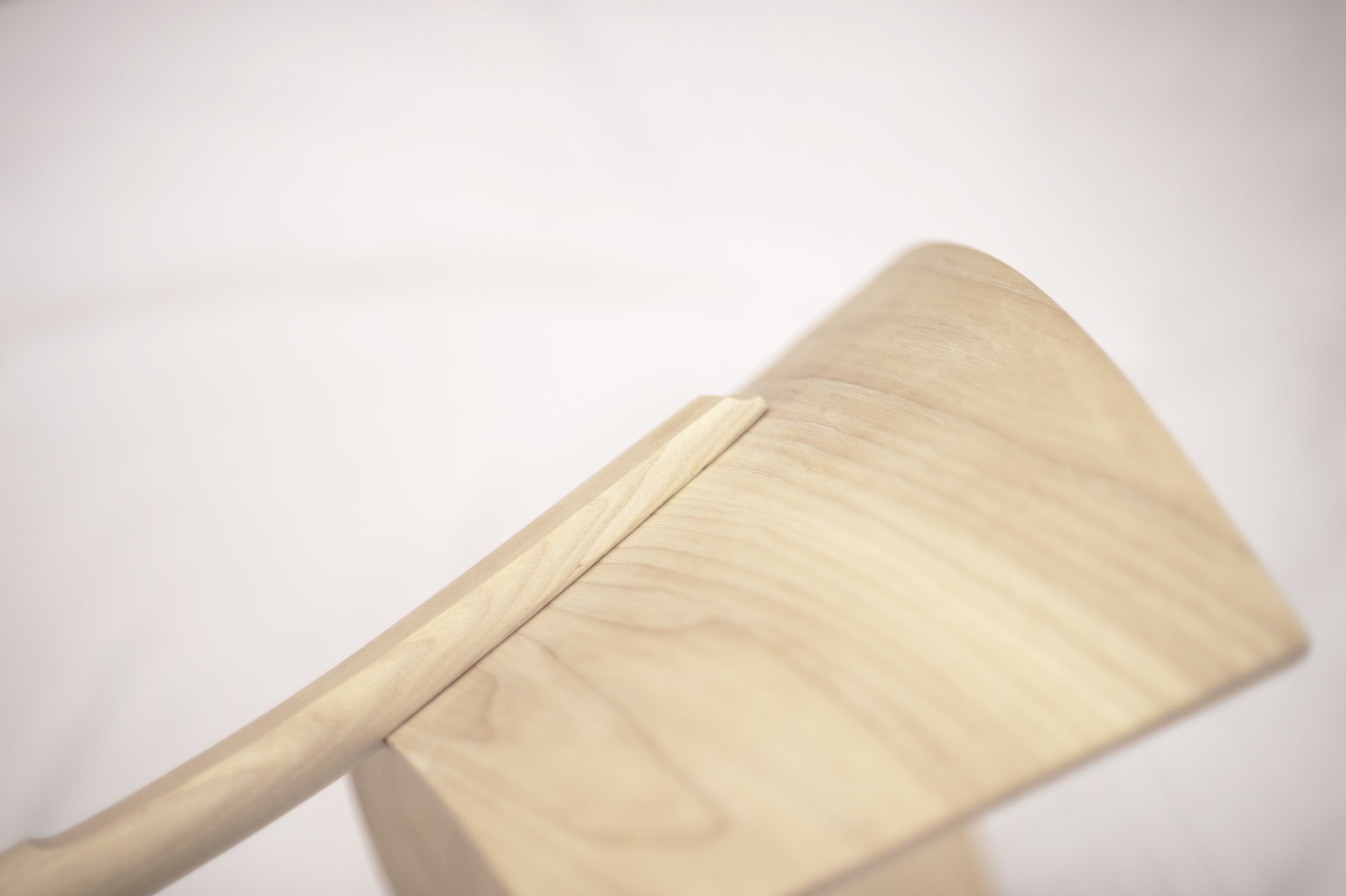 Close-up of a wooden rolling pin on a flat wooden board.