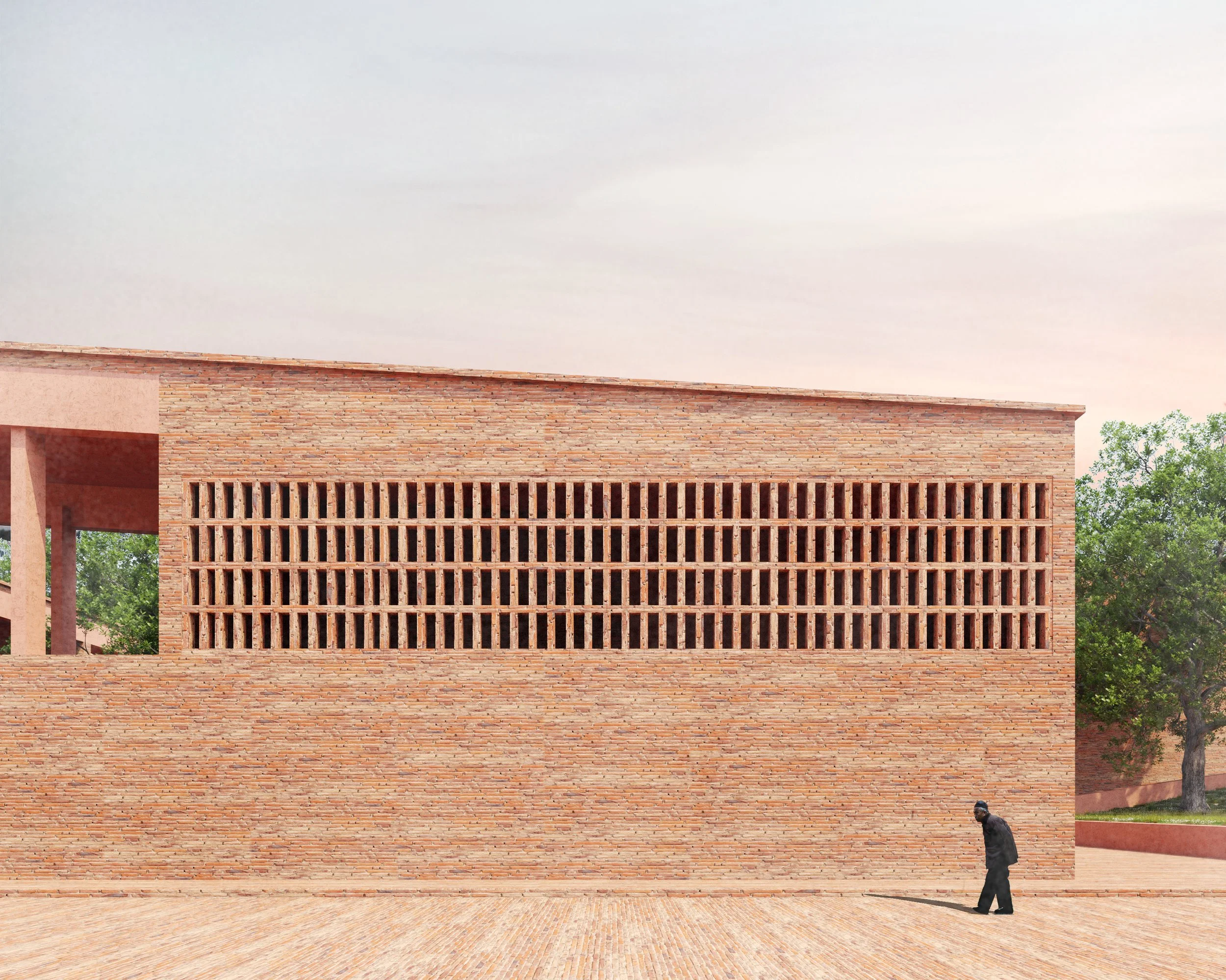 A person walking on a brick pathway near a modern brick building with large, evenly spaced vertical openings and greenery in the background.