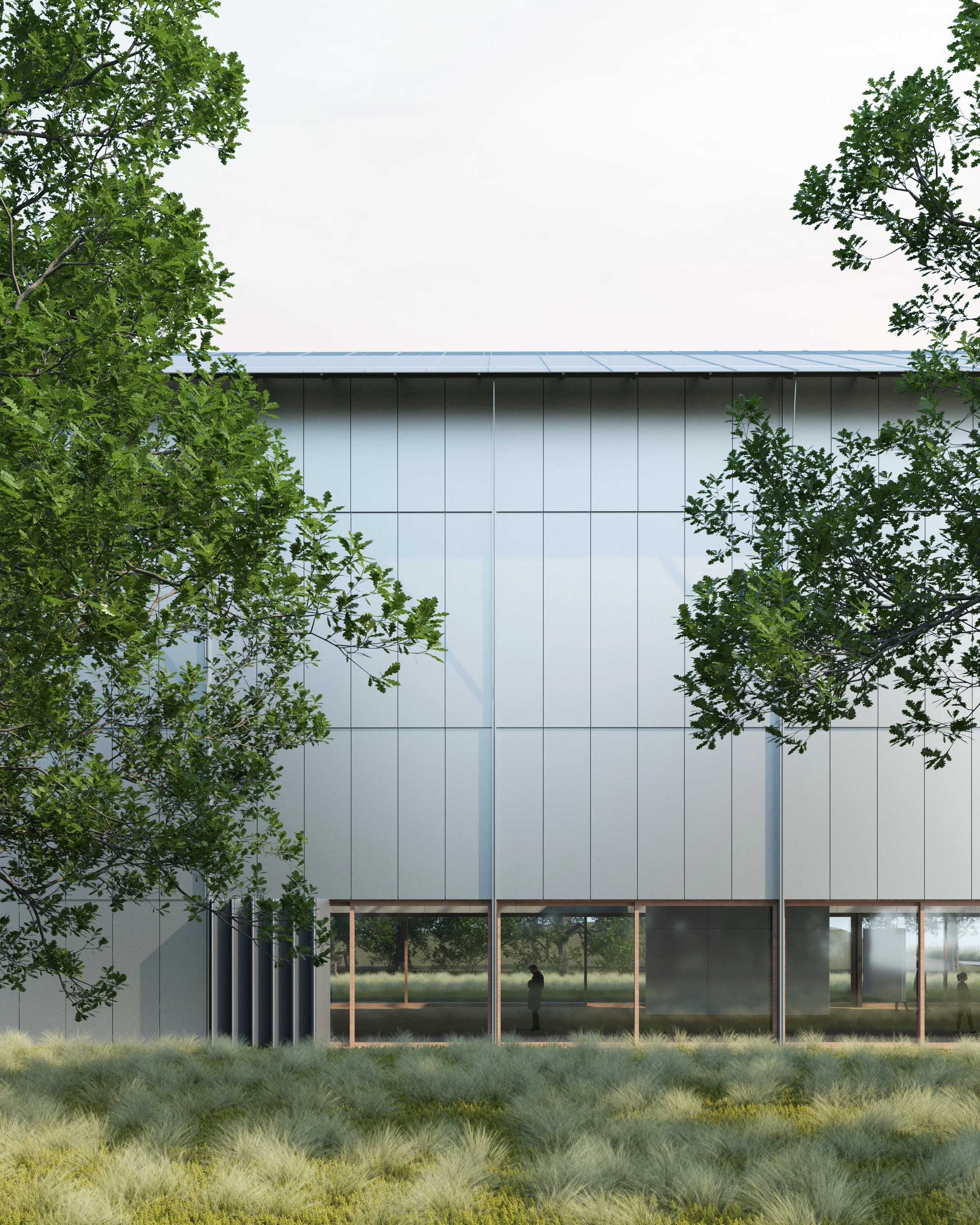 A modern building with large glass windows and a sleek design, surrounded by green trees and grass, with reflections of the trees visible on the glass.
