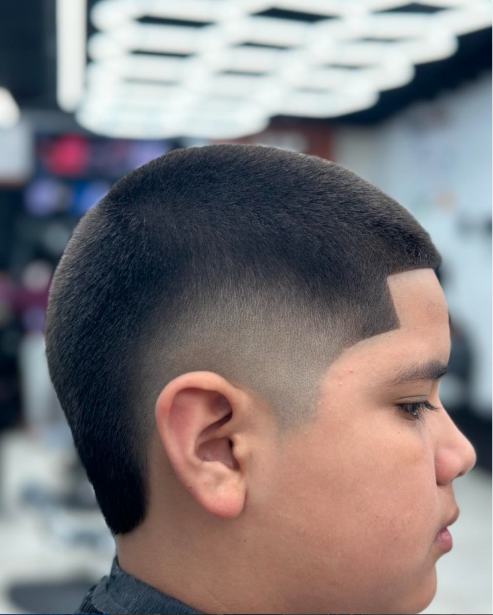 Young boy with a fresh fade haircut in a barbershop.