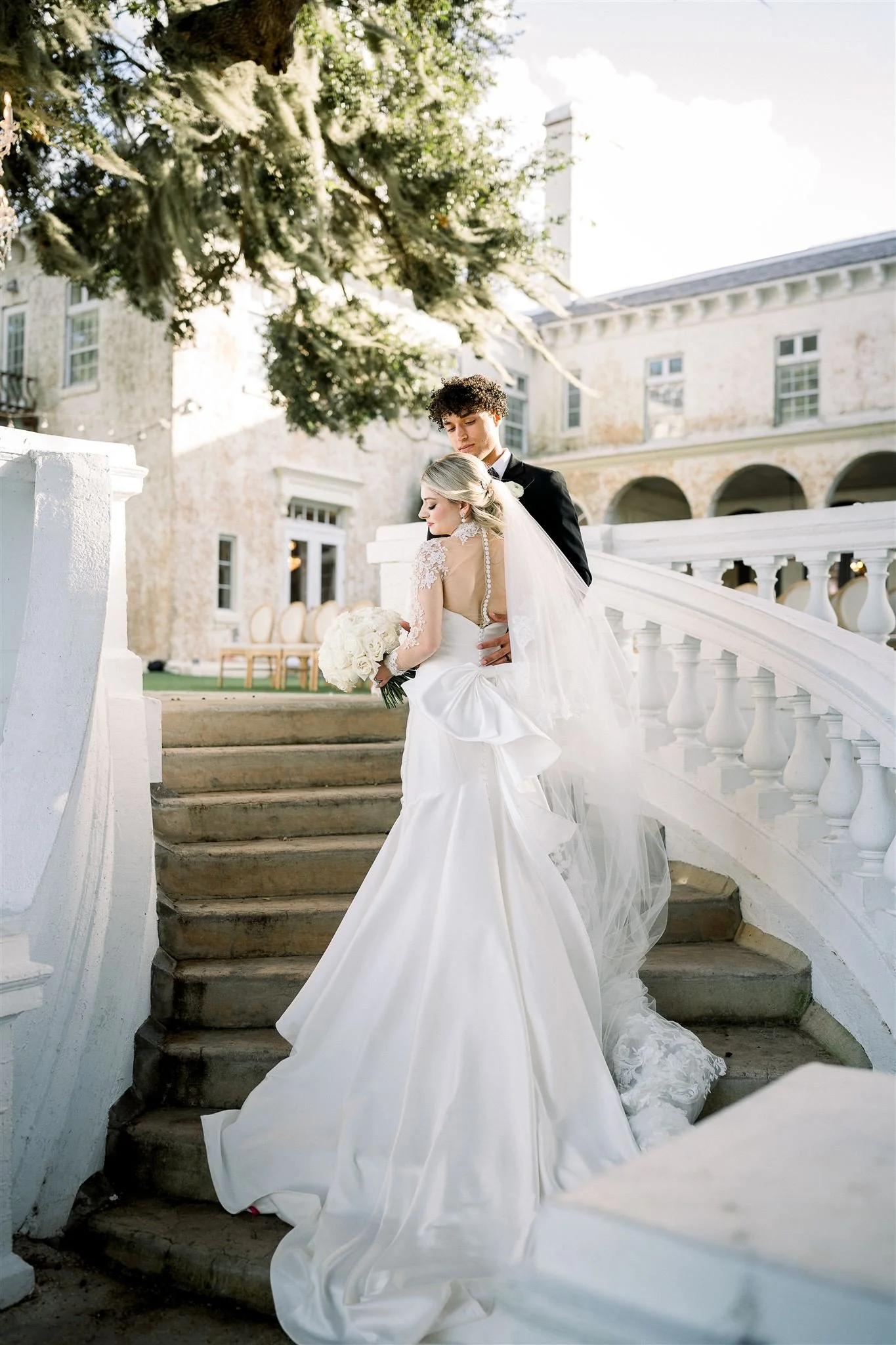 Couple on stairs at Bella cosa wedding venue golden hour
