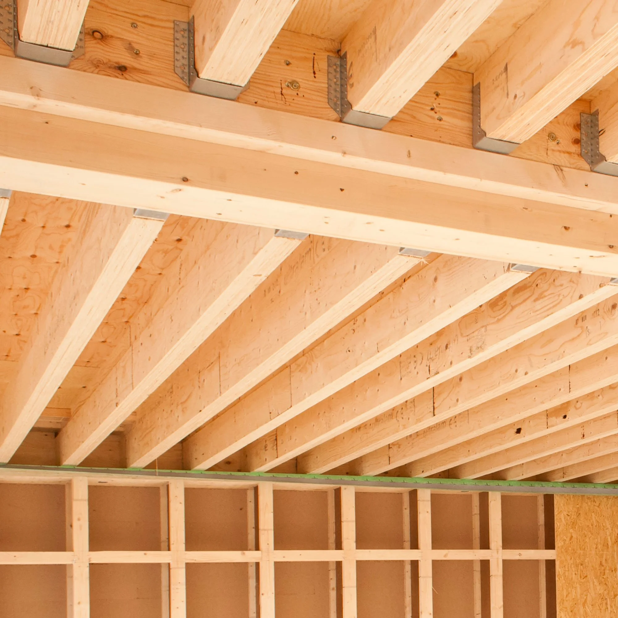 Interior of a building under construction with wooden framing and ceiling beams.